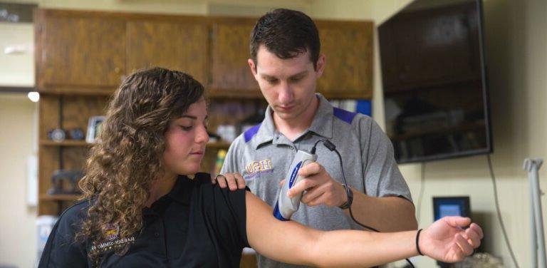Master of Science in Kinesiology student practices clinicals with patient